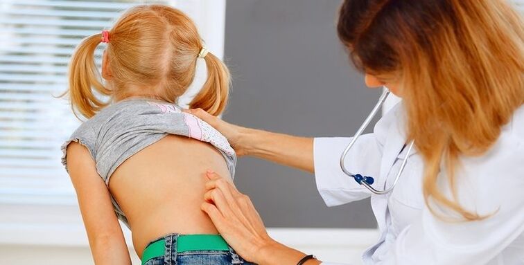 medico che esamina la schiena di un bambino con dolore lombare